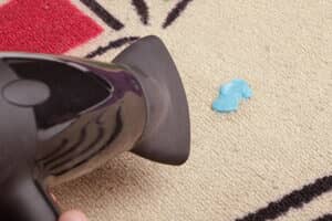 Person using a blow dryer to remove gum